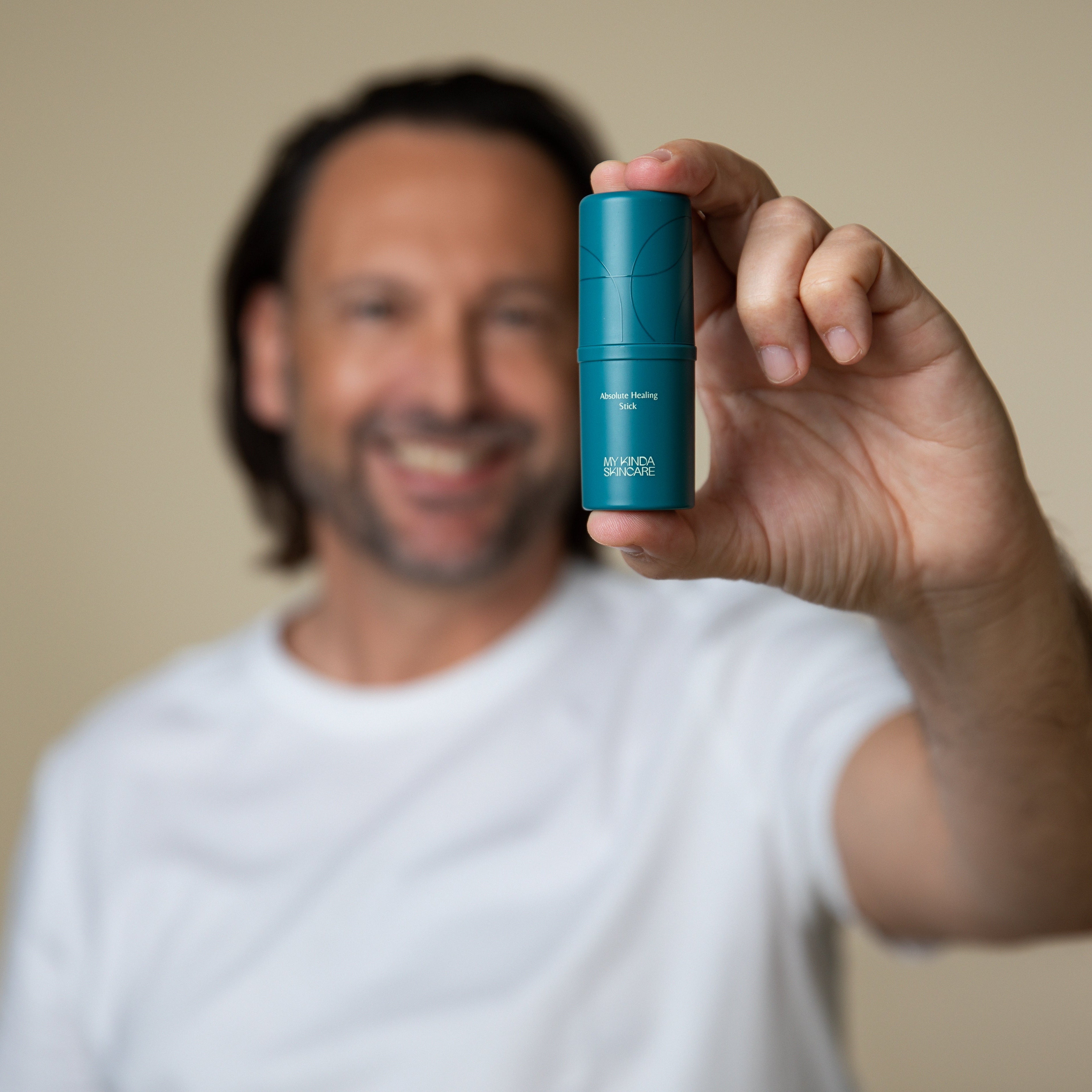 een man houdt de verpakking van de multi use balm vast. Deze is geschikt als unisex skincare