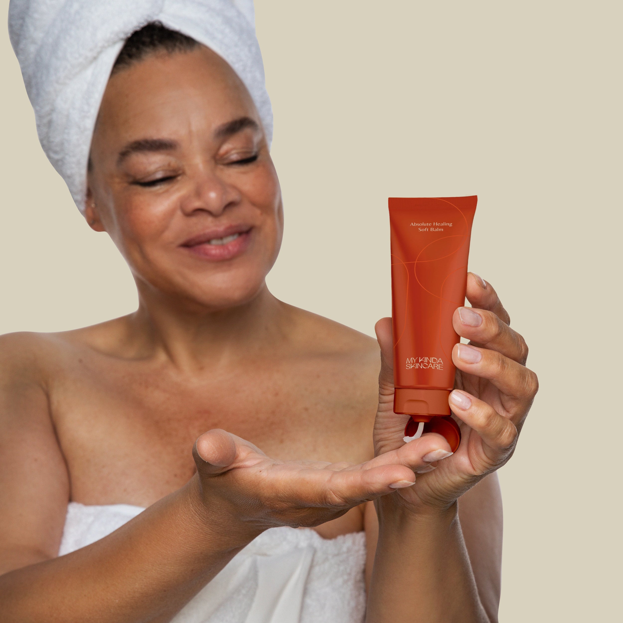 Vrouw houdt de My Kinda Skincare tube vast voor het gezicht. Sterk voedende en hydraterende balsem voor iedereen, gemaakt van gerecycled plastic
